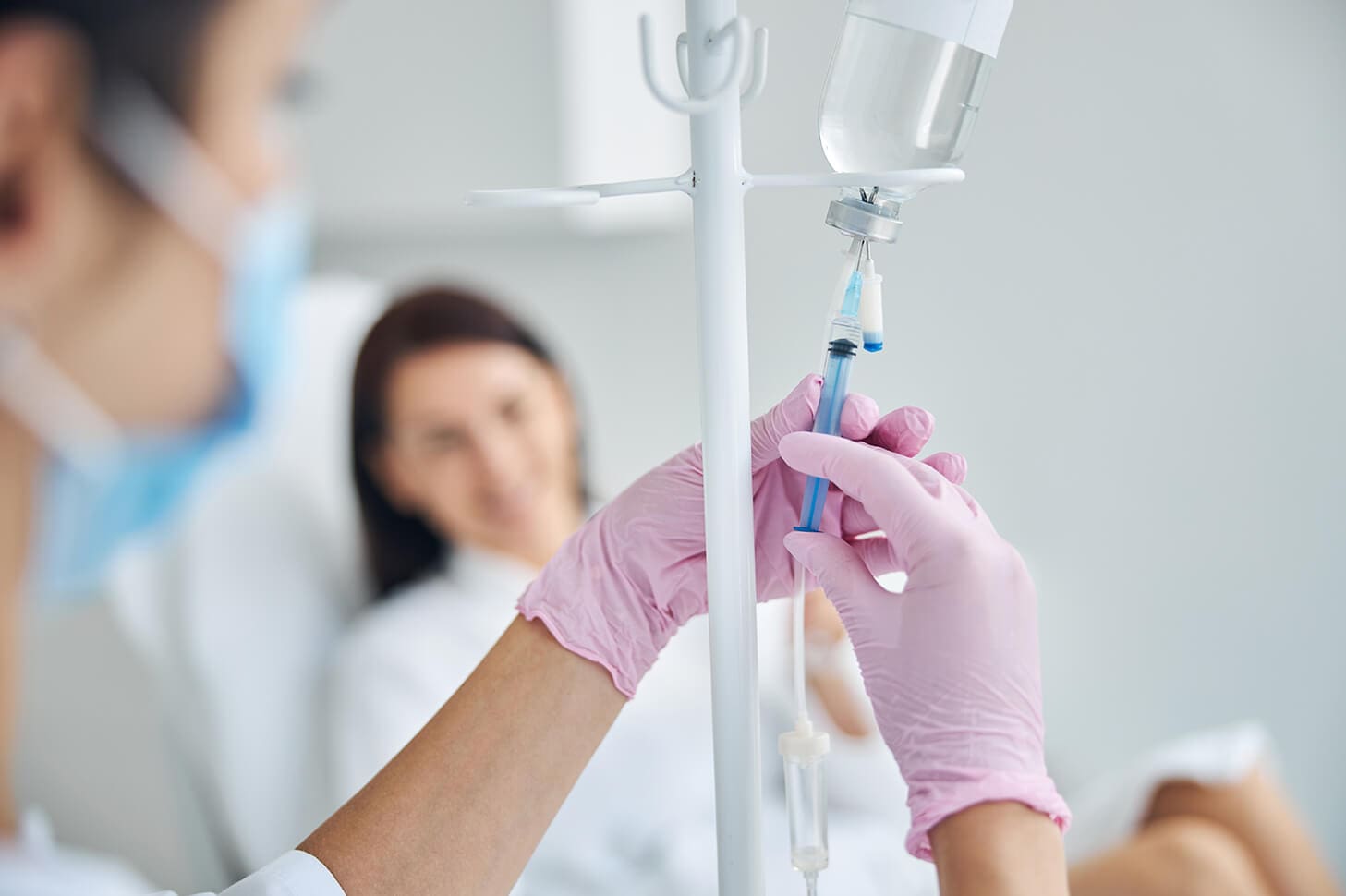 Nurse preparing an IV drip for a patient.