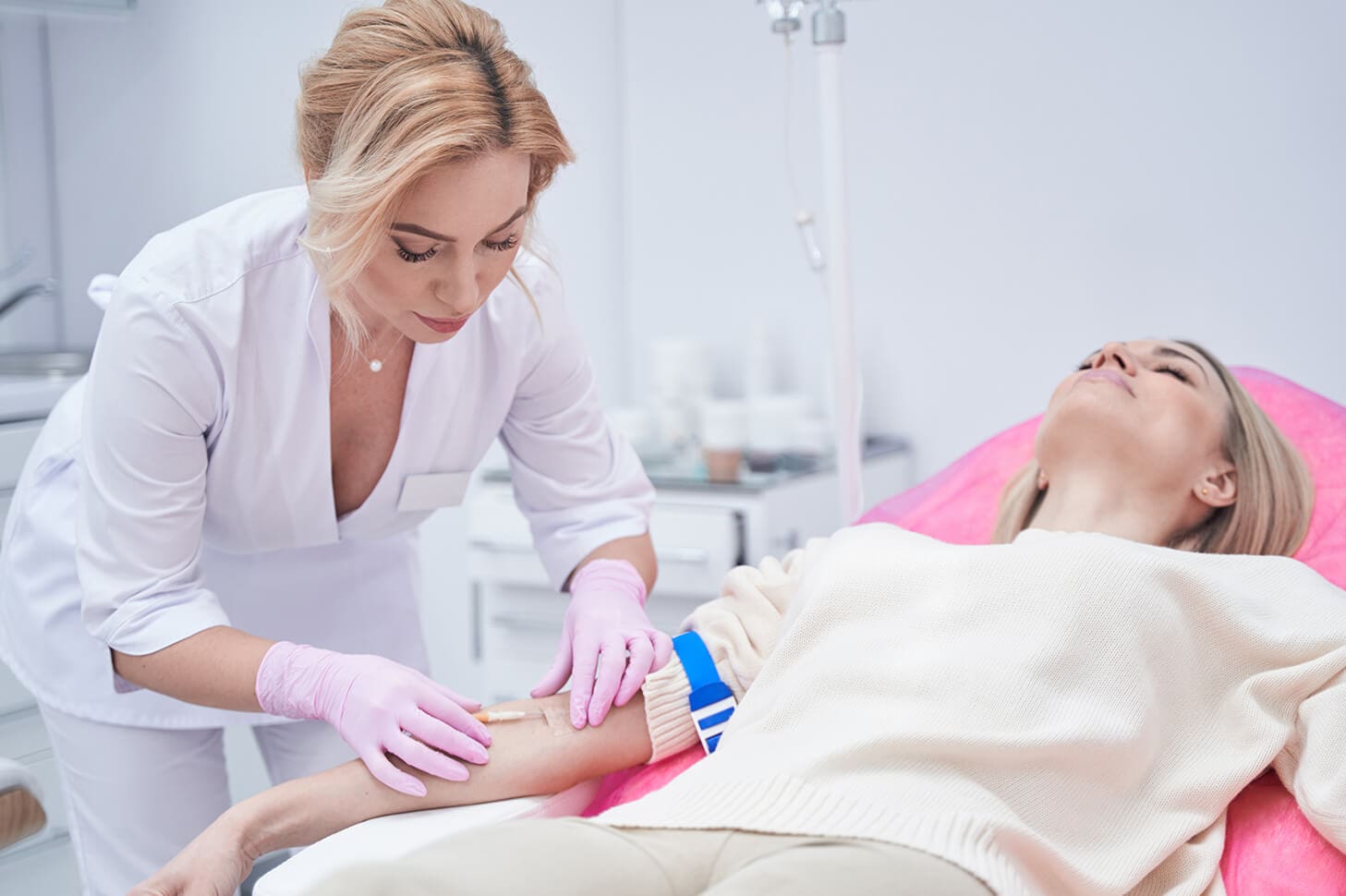 Nurse taking blood from patient's arm.